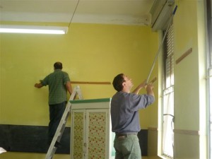 Padres de alumnos realizando trabajos de pintura en una de las aulas.